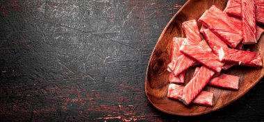 Ahşap tabakta yengeç eti. Karanlık bir arka plana karşı. Yüksek kalite fotoğraf