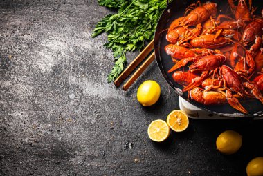 Maydanoz ve limonlu tencerede kaynamış kerevit. Siyah bir arka planda. Yüksek kalite fotoğraf