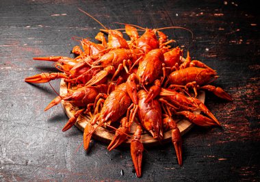 Yuvarlak bir kesme tahtasında kaynamış kerevit. Karanlık bir arka plana karşı. Yüksek kalite fotoğraf