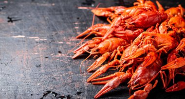 Masada bir sürü haşlanmış kerevit var. Karanlık bir arka plana karşı. Yüksek kalite fotoğraf