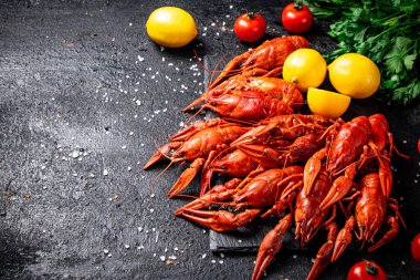 Limonlu, otlu ve domatesli haşlanmış kerevit. Siyah bir arka planda. Yüksek kalite fotoğraf