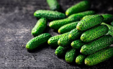 Masada olgun küçük salatalıklar var. Siyah bir arka planda. Yüksek kalite fotoğraf