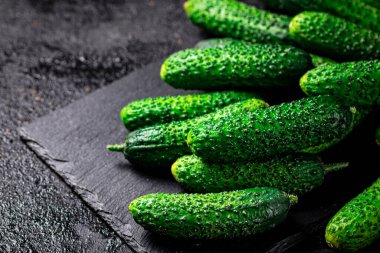 Bir avuç taze ev yapımı salatalık. Siyah bir arka planda. Yüksek kalite fotoğraf