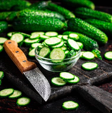 Salatalıklar kesme tahtasından kesilmiş. Siyah bir arka planda. Yüksek kalite fotoğraf