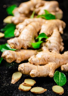Yapraklı mis kokulu zencefil parçaları. Siyah bir arka planda. Yüksek kalite fotoğraf