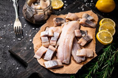 Kesme tahtasında salamura ringa balığı filetosu. Siyah bir arka planda. Yüksek kalite fotoğraf