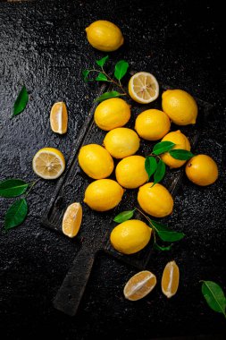 Kesme tahtasındaki tüm limonlar ve parçalar. Siyah bir arka planda. Yüksek kalite fotoğraf