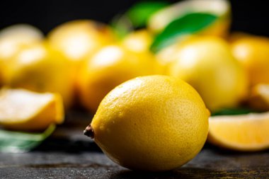 Masada yaprakları olan mis kokulu limonlar. Siyah bir arka planda. Yüksek kalite fotoğraf