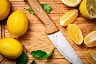 Bir bıçakla limonları parçalara ayırdı. Ahşap bir arka planda. Yüksek kalite fotoğraf