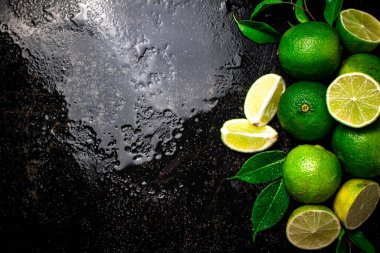 Parçalar ve yapraklı limon. Siyah, nemli bir arka planda. Yüksek kalite fotoğraf