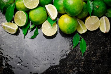 Parçalar ve yapraklı limon. Siyah, nemli bir arka planda. Yüksek kalite fotoğraf