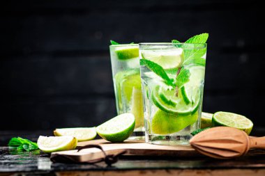 Kesme tahtasının üzerinde limon parçaları olan mojito. Kırsal bir arka planda. Yüksek kalite fotoğraf