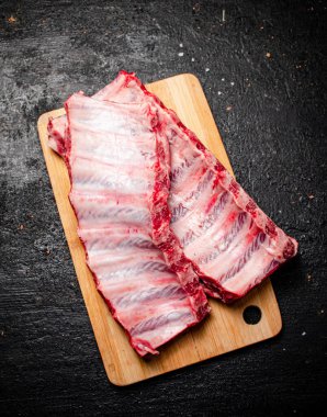 Kesme tahtasında çiğ pirzola. Siyah bir arka planda. Yüksek kalite fotoğraf