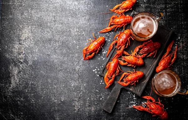 Crayfish Fervido Com Cerveja Uma Tábua Corte Num Fundo Preto — Fotografia de Stock
