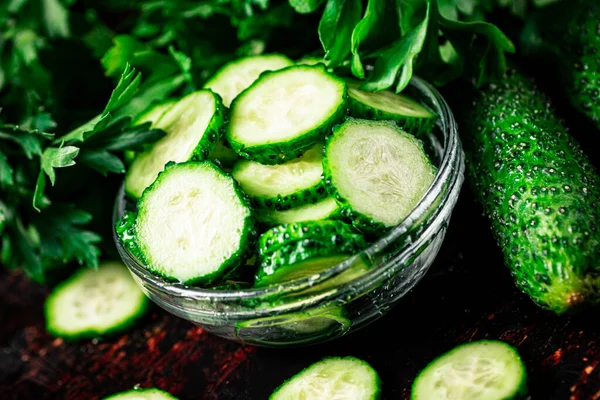 stock image Sliced and whole cucumbers on the table. Against a dark background. High quality photo