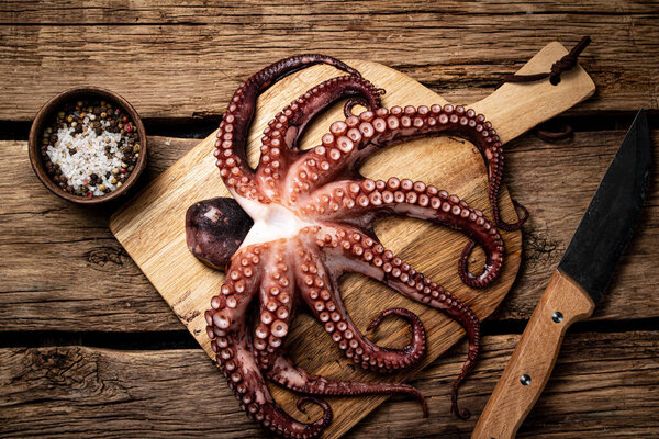Beautiful octopus on a cutting board. On a wooden background. High quality photo