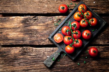 Kesme tahtasındaki dalda taze domatesler. Ahşap bir arka planda. Yüksek kalite fotoğraf