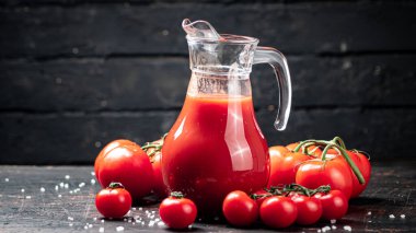 Masadaki olgun domateslerin suyu. Siyah tahta bir arka planda. Yüksek kalite fotoğraf