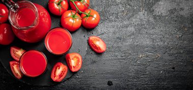 Taş bir tahtada domates suyu. Siyah bir arka planda. Yüksek kalite fotoğraf