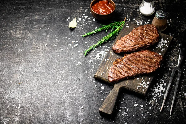 Grill Steak Una Tabla Cortar Madera Sobre Fondo Negro Foto —  Fotos de Stock