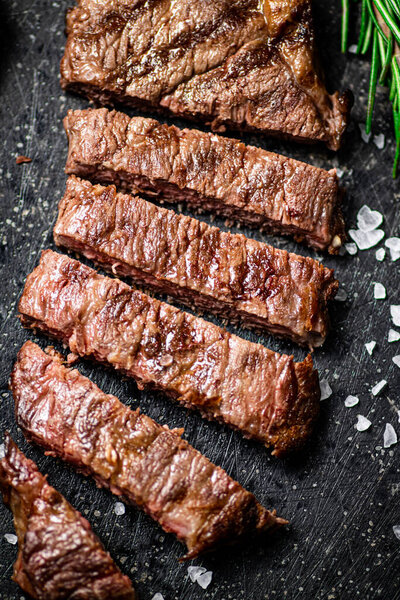 Pieces of delicious grilled steak. On a black background. High quality photo