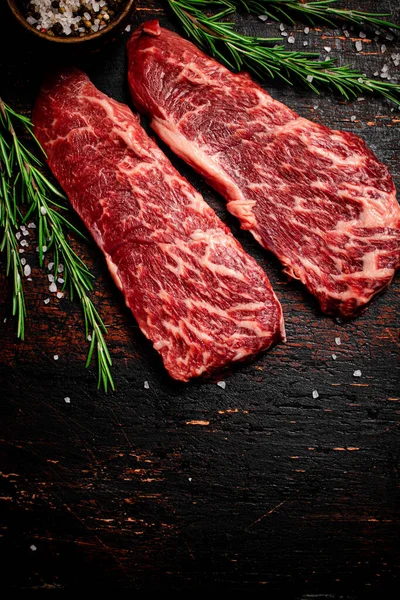 Rohe Steaks Mit Rosmarin Und Gewürzen Auf Dem Tisch Vor — Stockfoto