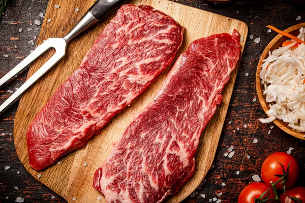 Rohe Steaks Auf Einem Holzschneidebrett Mit Gewürzen Auf Rustikalem Dunklem — Stockfoto