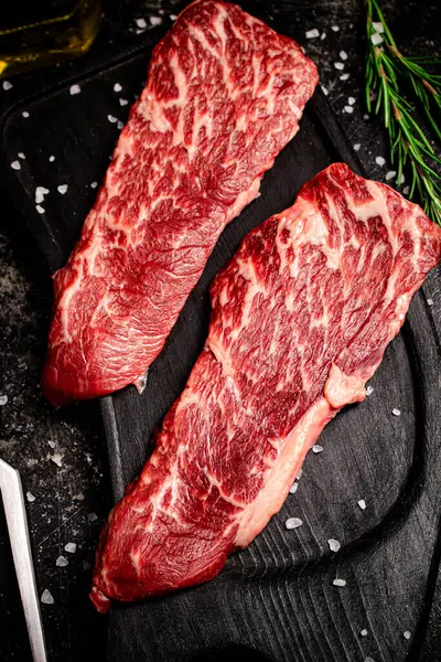 Rauwe Biefstuk Een Snijplank Een Zwarte Achtergrond Hoge Kwaliteit Foto — Stockfoto