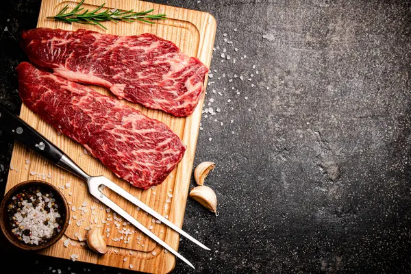 Rohe Steaks Auf Einem Hölzernen Schneidebrett Auf Schwarzem Hintergrund Hochwertiges — Stockfoto