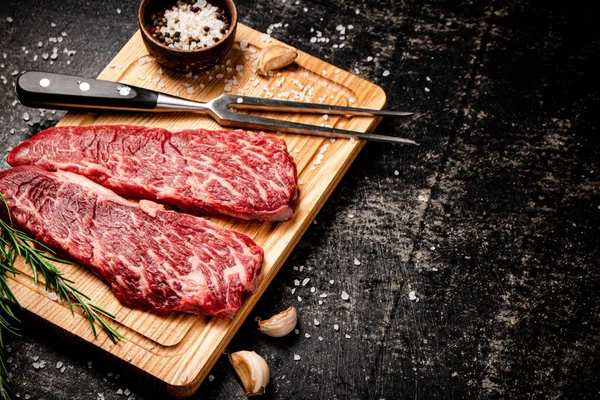 Rohe Steaks Auf Einem Hölzernen Schneidebrett Auf Schwarzem Hintergrund Hochwertiges — Stockfoto
