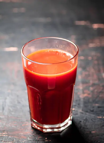 ガラスの熟したトマトからジュース 素朴な暗い背景に 高品質の写真 — ストック写真