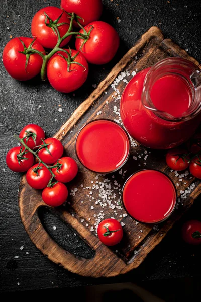 Kieliszki Soku Pomidorowego Desce Krojenia Czarnym Tle Wysokiej Jakości Zdjęcie — Zdjęcie stockowe