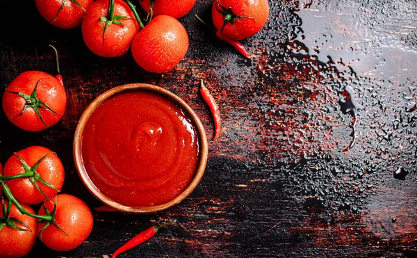 赤唐辛子の皿の中のトマトソース 暗い背景を背景に 高品質の写真 — ストック写真