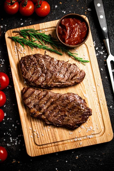 Grillezett Steak Egy Vágódeszkán Rozmaringgal Paradicsommal Fekete Háttérrel Kiváló Minőségű Stock Fotó