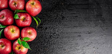 Ripe red apples with foliage. On a black background. High quality photo