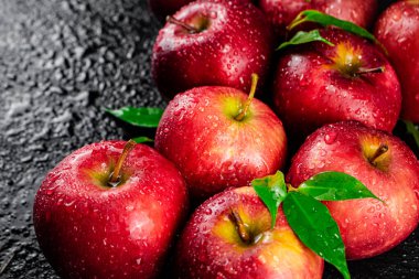 Ripe red apples with foliage. On a black background. High quality photo