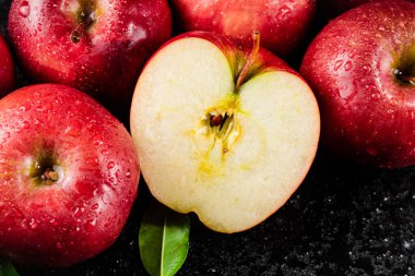 Half and whole fresh apples. On a black background. High quality photo