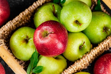 An assortment of red and green apples on the table. On a black background. High quality photo