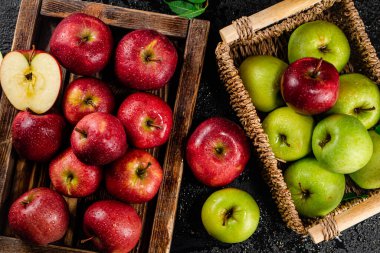 An assortment of red and green apples on the table. On a black background. High quality photo