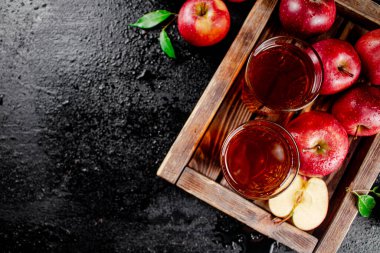 Apple juice on a wooden tray. On a black background. High quality photo