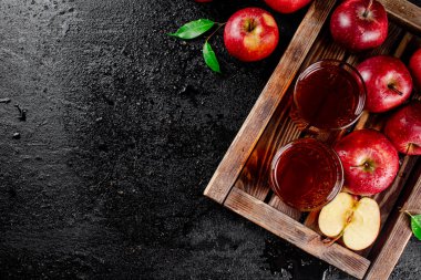 Apple juice on a wooden tray. On a black background. High quality photo