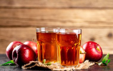 Freshly squeezed apple juice in a glass. On a wooden background. High quality photo