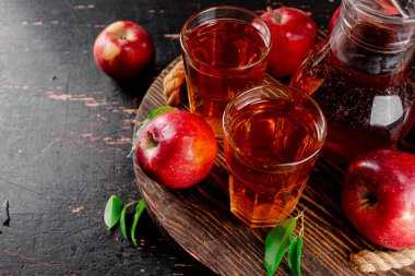 Apple juice on a wooden tray. On a rustic dark background. High quality photo