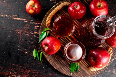 Apple juice on a wooden tray. On a rustic dark background. High quality photo