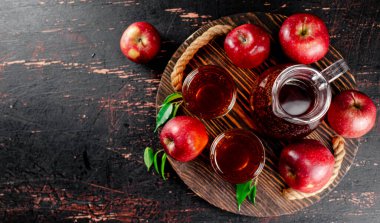 Apple juice on a wooden tray. On a rustic dark background. High quality photo