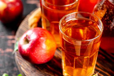 Apple juice on a wooden tray. On a rustic dark background. High quality photo