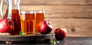 Juice from ripe red apples on tray. On a wooden background. High quality photo
