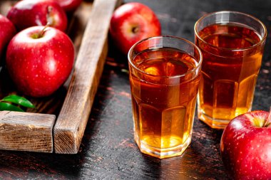 A glass of apple juice on the table. On a rustic dark background. High quality photo