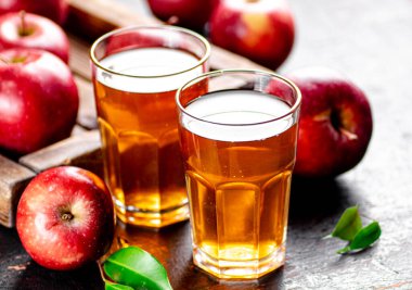 A glass of apple juice on the table. On a rustic dark background. High quality photo
