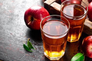 A glass of apple juice on the table. On a rustic dark background. High quality photo